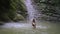 Young pretty woman bathing in small mountain lake in green tropical forest