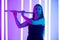 Young pretty woman in black dress plays the flute. Musician female posing in a dark studio against the backdrop of