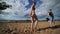 Young pretty woman in bra and underpants is dancing on summer beach near river