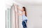 Young pretty woman hanging window curtain