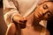 Young pretty woman has Thai massage. Close up of neck stretching. Concept of serene spa treatments.