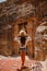 Young pretty woman in hat look at The Monastery, Petra`s largest monument, UNESCO World Heritage Site, Jordan