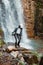 young pretty woman hiking enjoying view of waterfall