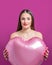 Young pretty woman holding a heart shaped air balloon. Valentine`s day concept