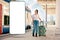 Young pretty woman holding her luggage and dreams about travel. Big smartphone with mock up and copy space. Train