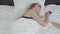 Young pretty woman lying in bed in the morning. The girl turning off the alarm clock on her cell phone and sharply