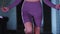 Young pretty woman in purple sports suit jumping over the jumping rope in the gym