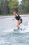 Young pretty woman riding wakeboard on wave