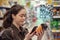 Young pretty woman scans a QR code product in the supermarket. The concept of modern technology