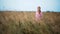 Young pretty woman in shirt poses in summer wheat field