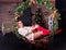 Young pretty woman sitting on a hanging bench in the Christmas decor. The inscription 2020 is behind it