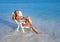 Young pretty woman tans in beach chair in sea