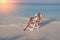 Young pretty woman tans in beach chair in sea , toning