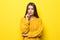Young pretty woman thinking wearing in yellow sweater isolated on yellow background