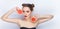 Young pretty woman trendy makeup bright red lips bun hairstyle bare shoulders act the ape with grapefruits white studio background