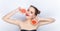 Young pretty woman trendy makeup bright red lips bun hairstyle bare shoulders act the ape with grapefruits white studio background