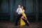 Young pretty woman in yellow dress and man dance tango