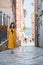 young pretty woman in yellow dress walking by small porec city streets sea on background