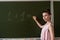 young primary female teacher written on chalkboard one plus one