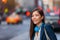Young professional Asian woman hip with tech device headphones walking on NYC New York city street commuting after work