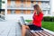 Young professional business woman sitting outdoor with computer