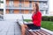 Young professional business woman sitting outdoor with computer