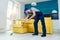 Young professional cleaner washing the floor. Janitor cart.