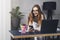 Young professional doing creative project on laptop. Girl sitting by computer at office desk. Digital tools and solutions for