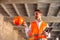 Young professional engineer with tablet and hard hat in hands