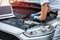 Young professional female mechanic inspects under the hood of a car in an auto repair shop