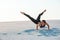 Young professional gymnast woman dance outdoor - sand beach