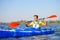 Young Professional Kayaker Paddling Kayak on River under Bright Morning Sun. Sport and Active Lifestyle Concept