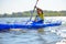 Young Professional Kayaker Paddling Kayak on River under Bright Morning Sun. Sport and Active Lifestyle Concept