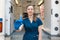 Young professional nurse in medical uniform, show syringe in her hands at ambulance background