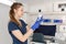 Young professional nurse in medical uniform, show syringe in her hands at ambulance background