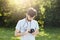 Young professional photographer looking at his camera trying to tune objective going to make photos of nature landscapes. Handsome