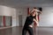 Young professional trainer woman in black sportswear engaged in a fitness studio. Beautiful girl in training in a sport class.