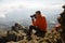 Young professional traveller man with dslr camera shooting outdoor fantastic mountain landscape. Hiker sits on a rock at