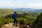 Young professional traveller man with dslr camera shooting outdoor fantastic mountain landscape. Hiker stands on a rock