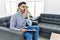 Young psychologist man at consultation office bored yawning tired covering mouth with hand