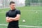 A young pumped man in sportswear stands against the background of the football gate. The concept of football coach