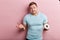 Young puzzled man holding a single roll of toilet paper