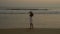 Young ramantic gentle girl in a hat walking on the shore of the Pacific Ocean. Woman in a white dress at sunset. soft