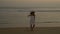 Young ramantic gentle girl in a hat walking on the shore of the Pacific Ocean. Woman in a white dress at sunset. soft