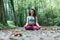 Young rasta woman doing yoga lotus pose in the park