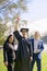 Young recently graduated boy, dressed in cap and gown, with his degree in hands