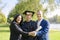 Young recently graduated boy, dressed in cap and gown, with his degree in hands, celebrating with his multi ethnic  family on the