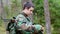 Young recruit with optical rifle in forest
