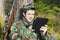 Young recruit with optical rifle in forest