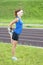 Young Red Haired Ginger Caucasian Female in Athletic Sportgear Having Legs Stretching Exercises Outdoors